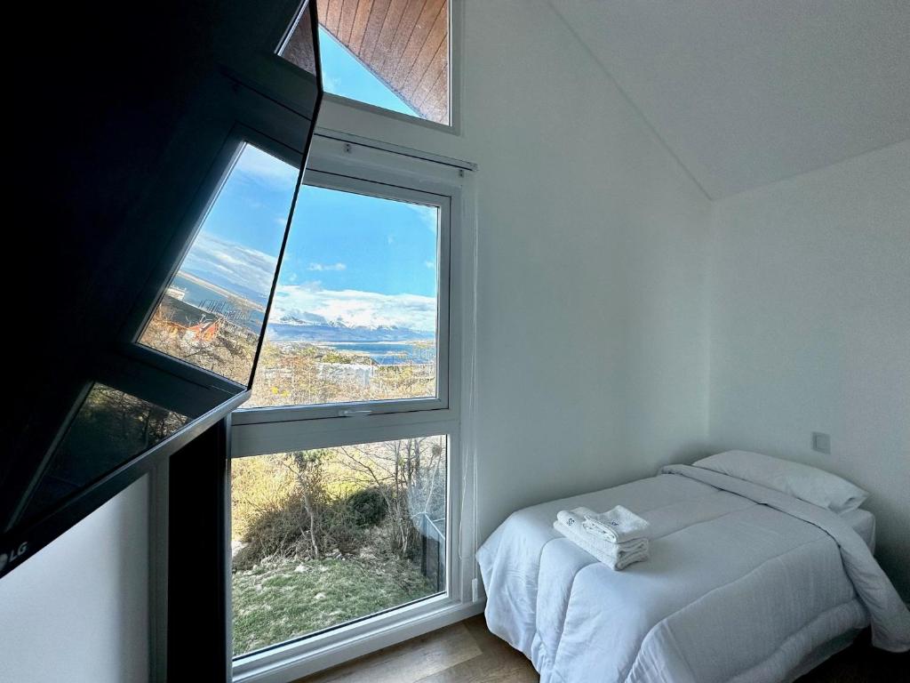 una camera con un letto e una grande finestra di Starigrad a Ushuaia