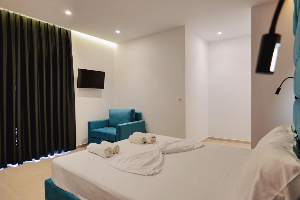 a bedroom with a bed and a blue chair at Vila Shpetimi in Ksamil