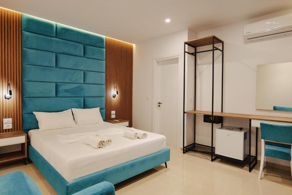 a bedroom with a large bed with a blue headboard at Vila Shpetimi in Ksamil