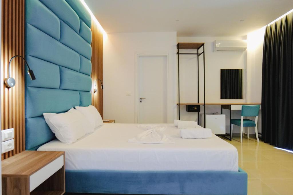 a bedroom with a large bed with a blue headboard at Vila Shpetimi in Ksamil