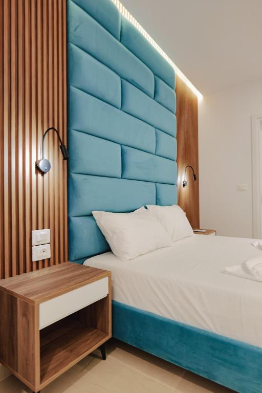 a bed with a blue headboard in a room at Vila Shpetimi in Ksamil