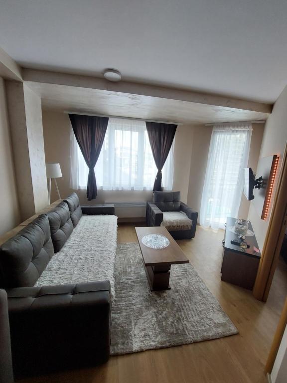 a living room with a couch and a table at Golden Apartman in Zlatibor