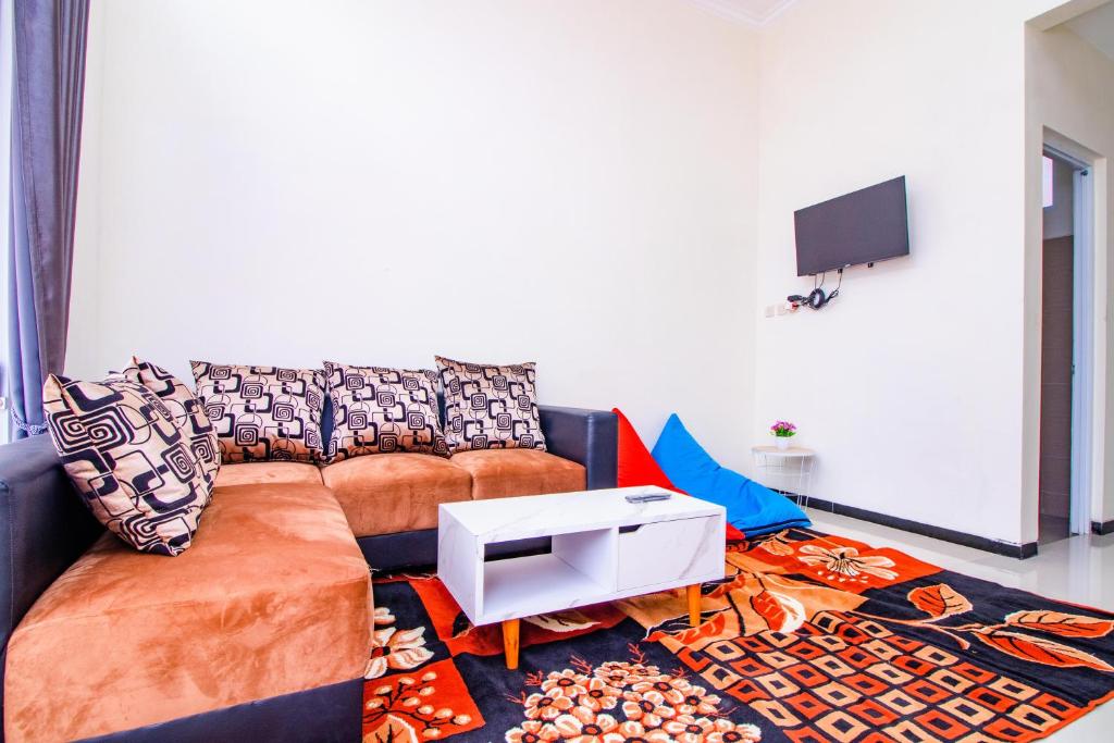 巴图Villa Mulyo E4 by Sans Villa的客厅里有一张沙发和一台电视