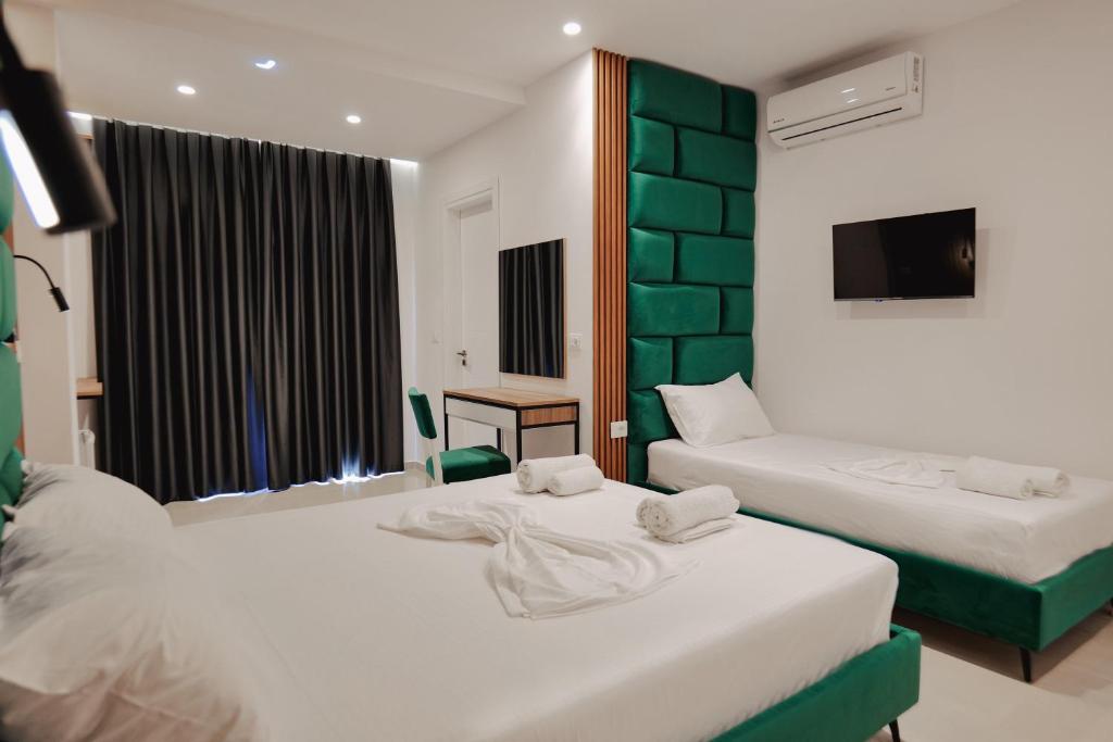a hotel room with two beds and a television at Vila Shpetimi in Ksamil