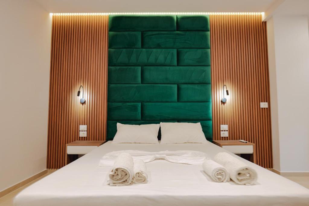 a bedroom with a bed with a green headboard at Vila Shpetimi in Ksamil