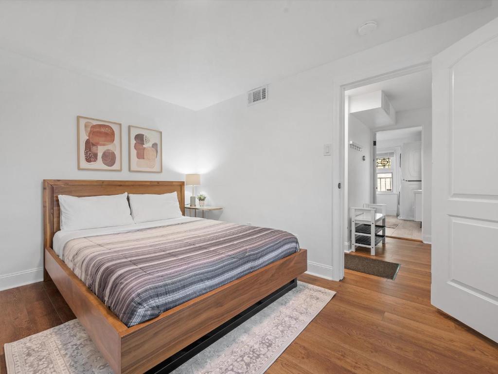 a bedroom with a bed and a white wall at Shadyside, Pittsburgh, Modern and Stylish 1 Bedroom Unit5 with Free Parking in Pittsburgh