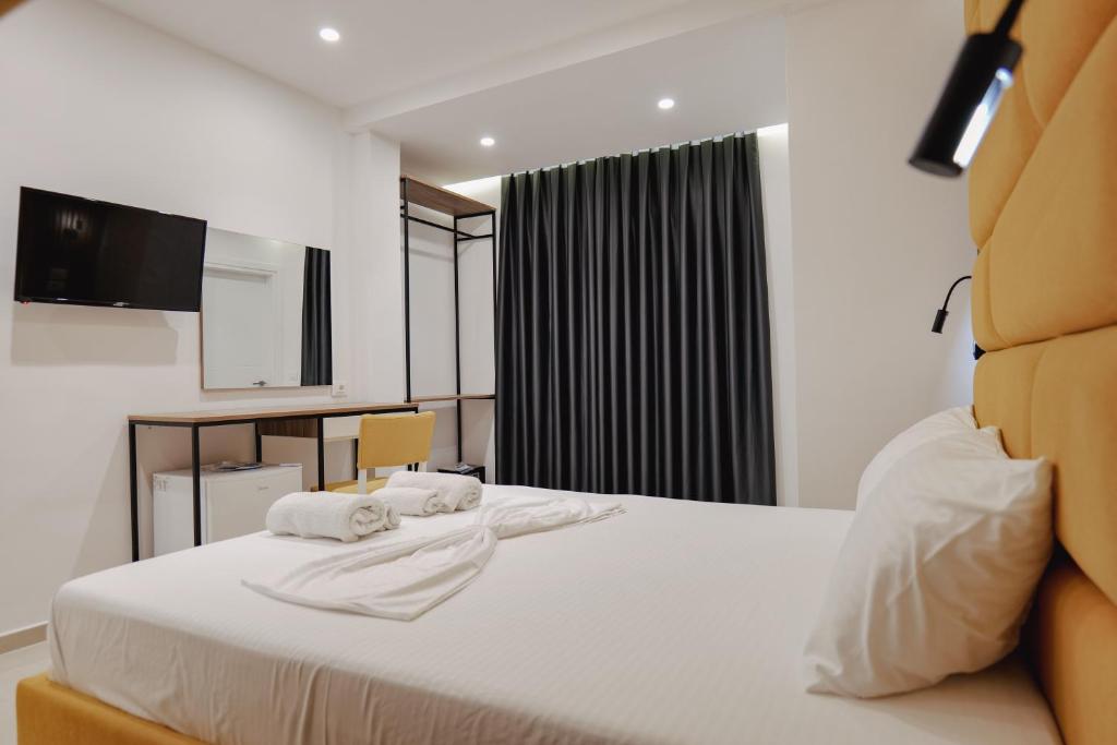 a hotel room with a bed with towels on it at Vila Shpetimi in Ksamil