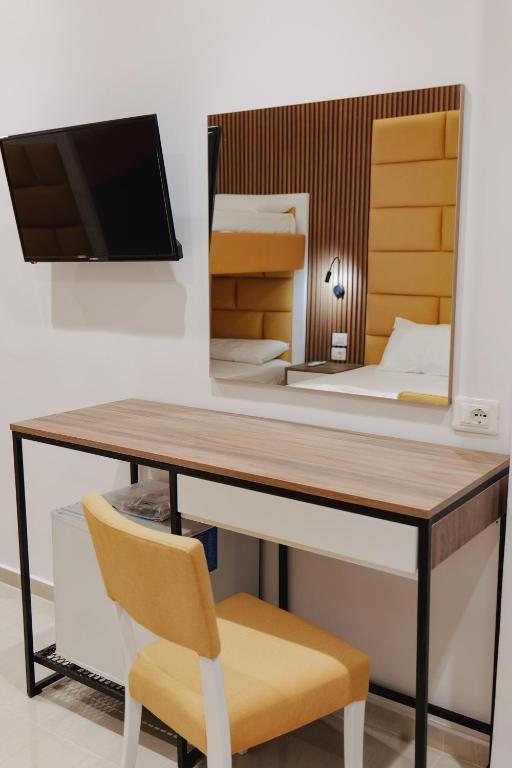 a desk in a room with a bed and a mirror at Vila Shpetimi in Ksamil