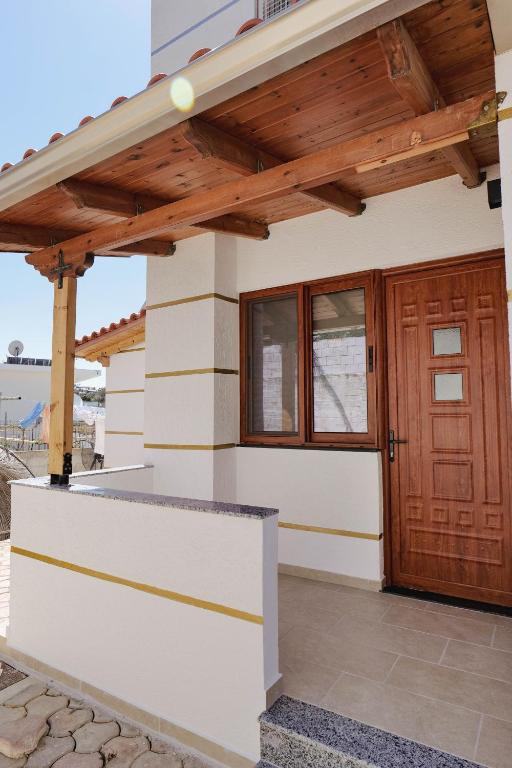 a house with a wooden door and a porch at Vila Shpetimi in Ksamil