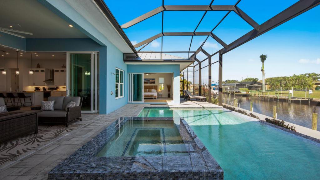 una piscina cubierta en una casa con techo de cristal en BRAND NEW! Direct Sailboat Access, Breathtaking Saltwater Pool - Villa Blue Lagoon - Roelens, en Cabo Coral