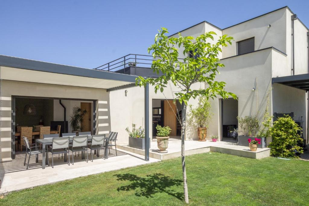 Casa con patio con mesa y sillas en Maison des Fleurs, en Vedène