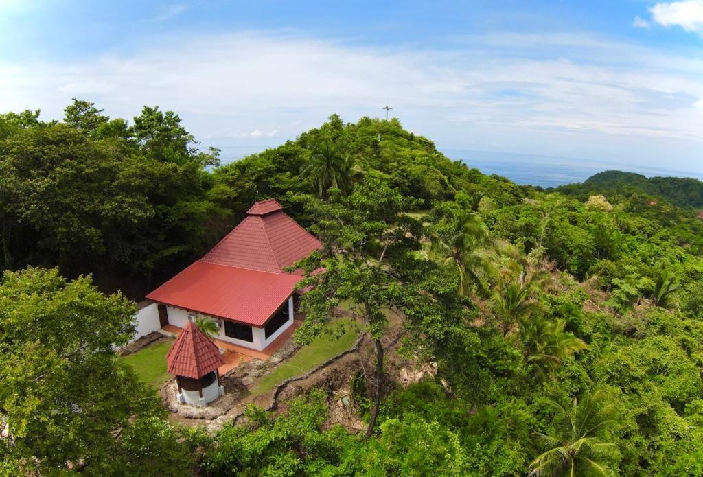 una pequeña casa con techo rojo en la cima de una colina en Sweet Jungle Beach, en Bejuco