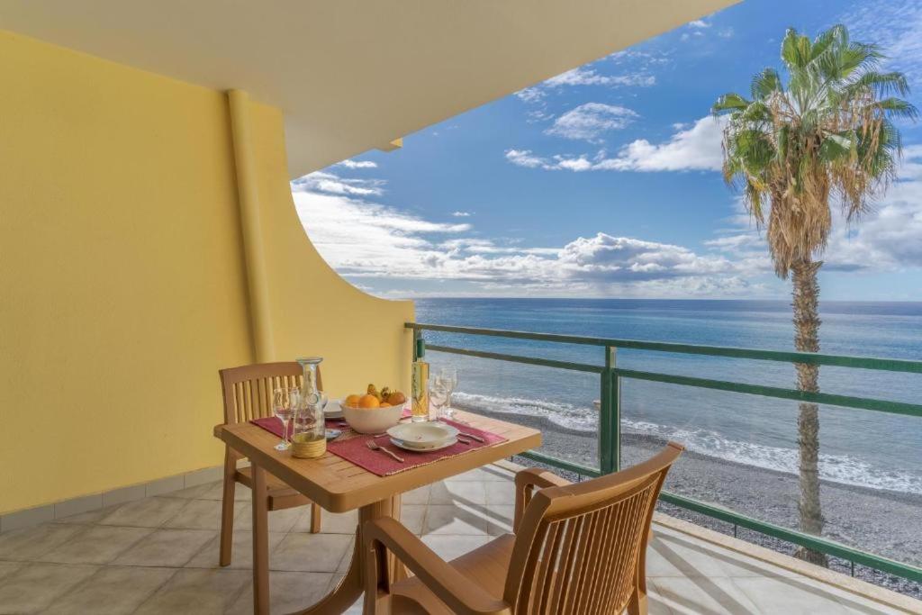 a dining room with a table and a view of the ocean at Tranquil Beachside Stay - Atlantic Gardens Beach in Funchal