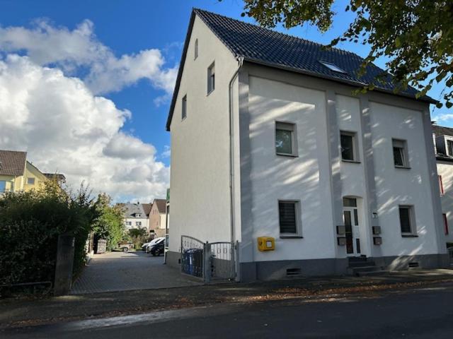 een wit gebouw aan de straatkant bij Rheinischer Hof Appartements in Leverkusen