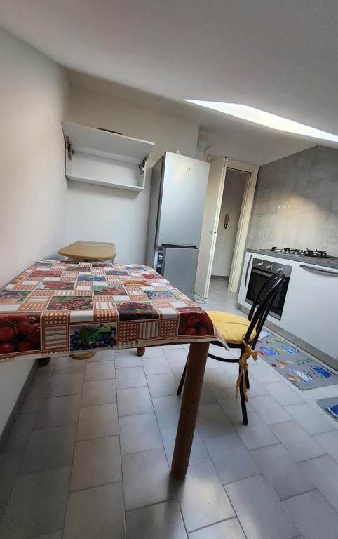 una camera con tavolo e una cucina con frigorifero di APPARTAMENTO ALESSANDRIA BJOUX ad Alessandria