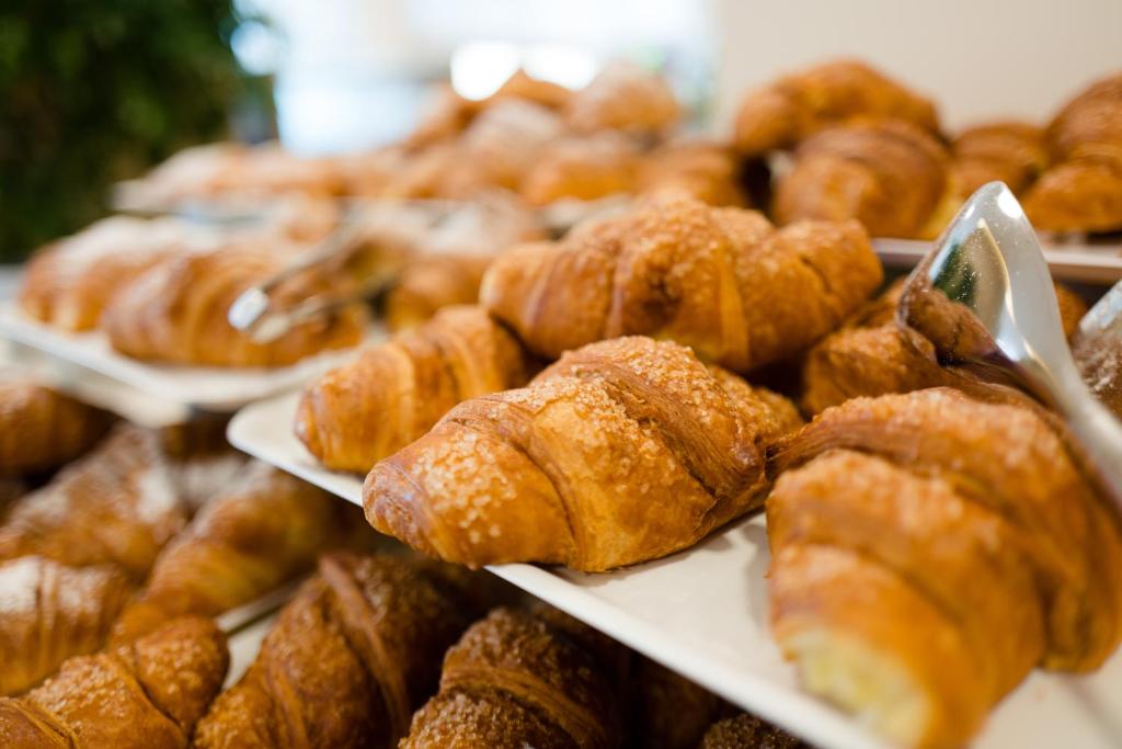 a display of pastries and croissants on plates in a bakery at Laguna Park Hotel 4Superior in Bibione