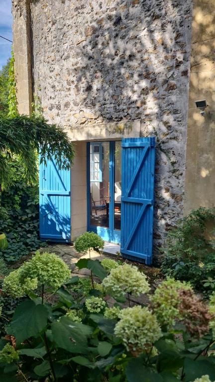 a house with blue doors and a garden with plants at gîte du bambou bleu 