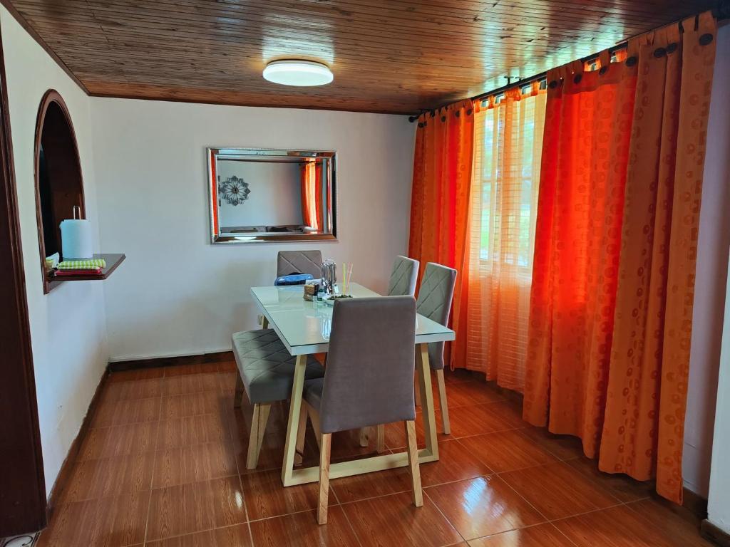 a dining room with a table with chairs and a mirror at Casa amoblada Dosquebradas in Dosquebradas