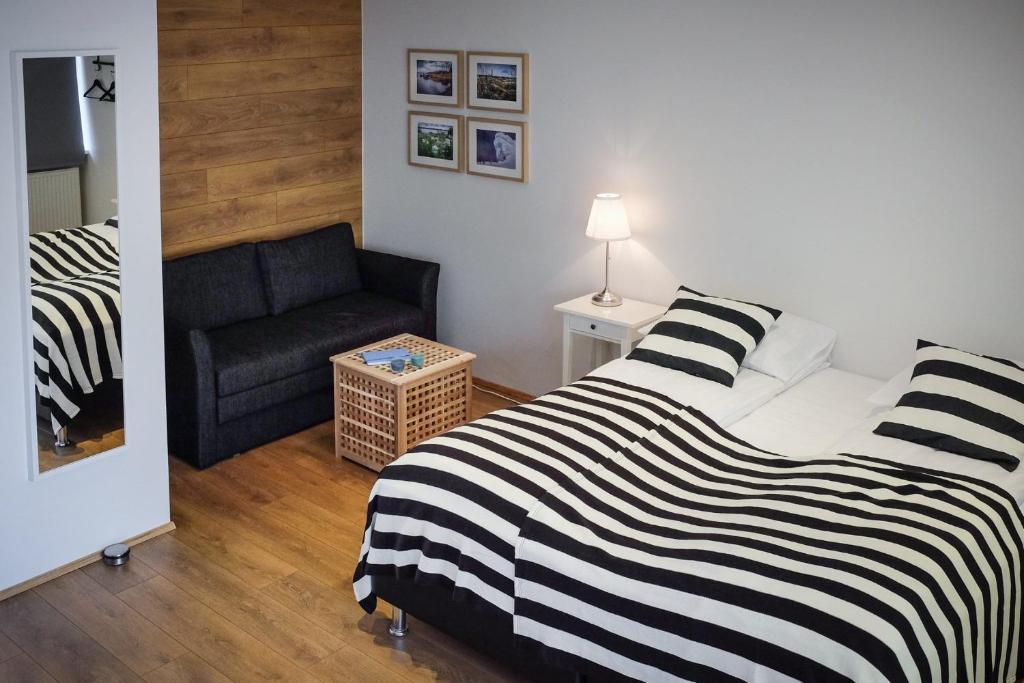 een slaapkamer met een bed en een bank bij Thoristun Apartments in Selfoss