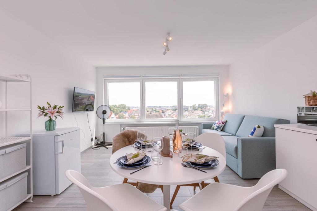 Il comprend une cuisine et un salon avec une table et des chaises. dans l'établissement Moderne lichtrijke studio vlakbij strand en casino Middelkerke, à Middelkerke