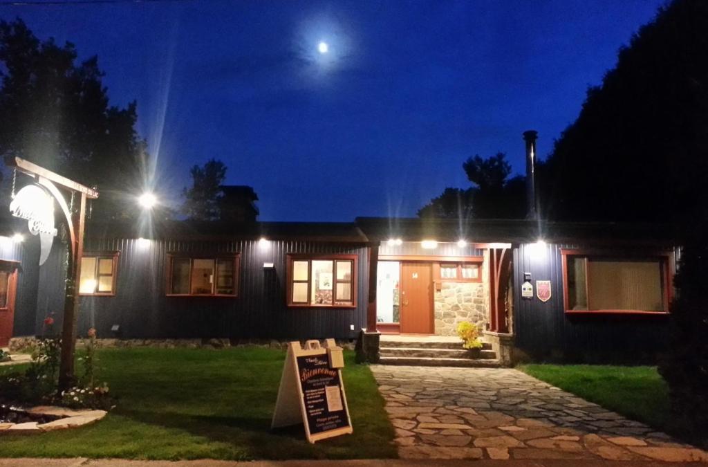 a house lit up at night with lights at Auberge Aux Nuits de Rêve in Sainte-Agathe-des-Monts