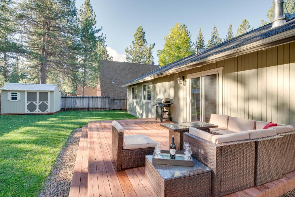 a patio with wicker furniture on a wooden deck at Cozy Lake Tahoe Home with Yard, Near Ski Resorts! in South Lake Tahoe