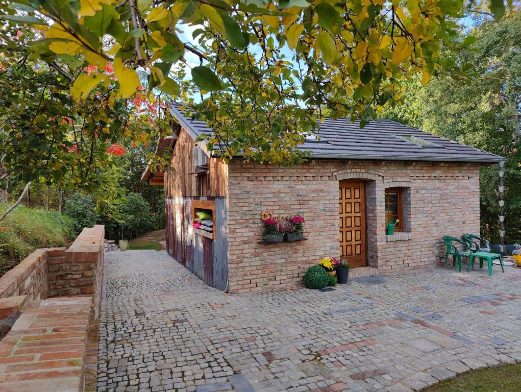 a small brick building with a table and chairs at DOMAGAŁA domek całoroczny in Łagów