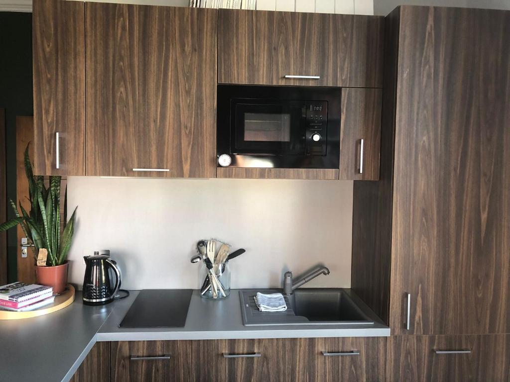 a kitchen with a sink and a microwave at Studio Flat in London