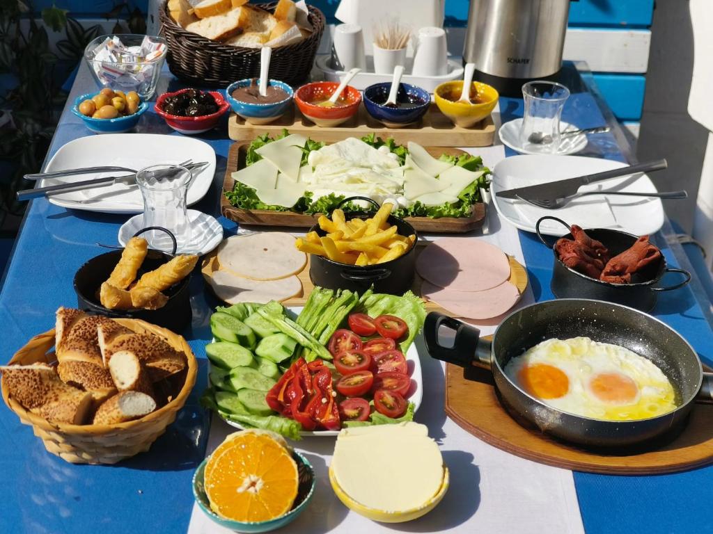 una mesa cubierta con muchos tipos diferentes de comida en MAVİ PALAS HOTEL, en Büyükada