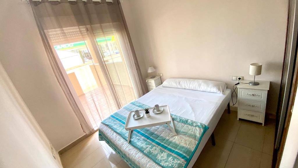 a small bed in a room with a window at Apartamentos Carlton VyB in Denia
