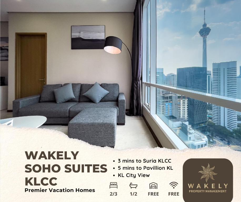 een woonkamer met een bank en een groot raam bij Soho Suites KLCC by Wakely Kuala Lumpur in Kuala Lumpur