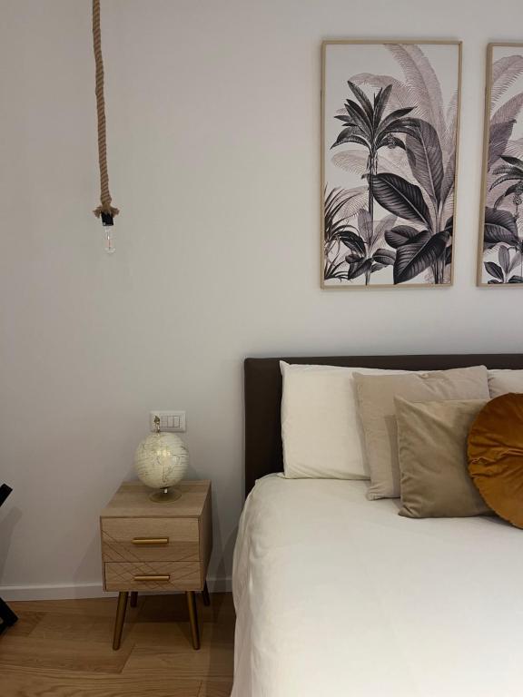 um quarto com uma cama, uma mesa de cabeceira e uma fotografia em Il Cortile em Enna