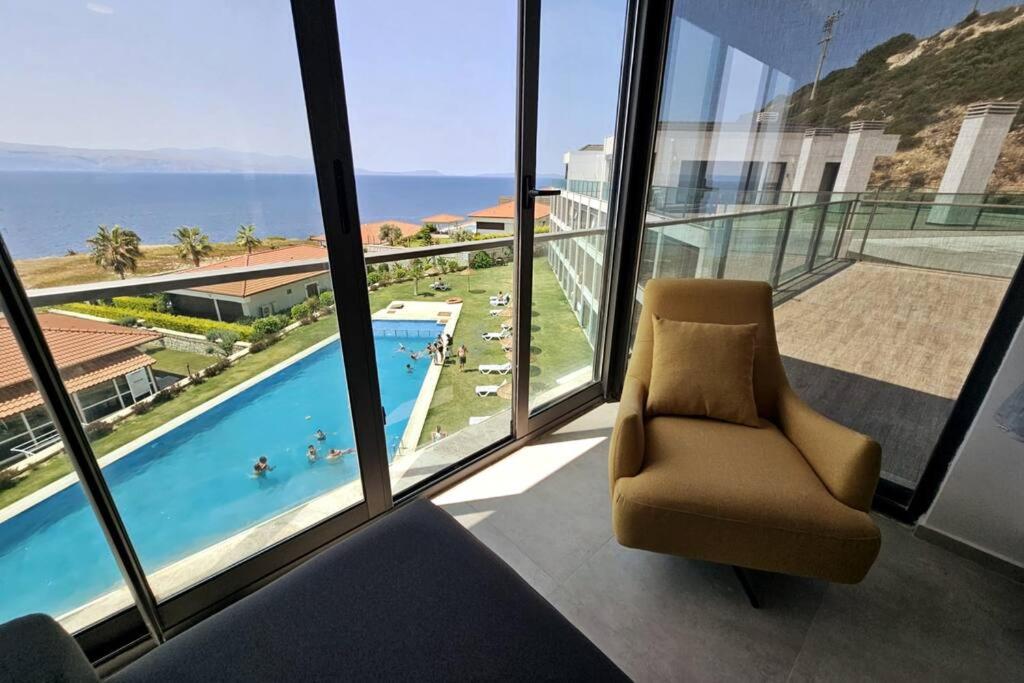 a chair in a room with a view of a swimming pool at Romantic Sea and Chios View Flat in Cesme