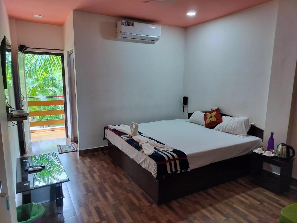 a bedroom with a bed in a room with a window at Kalapani Nest in Port Blair