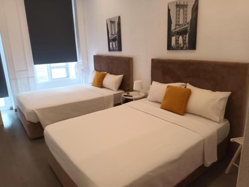- 2 lits dans une chambre avec 2 fenêtres dans l'établissement Guesthouse Franco, à Porto