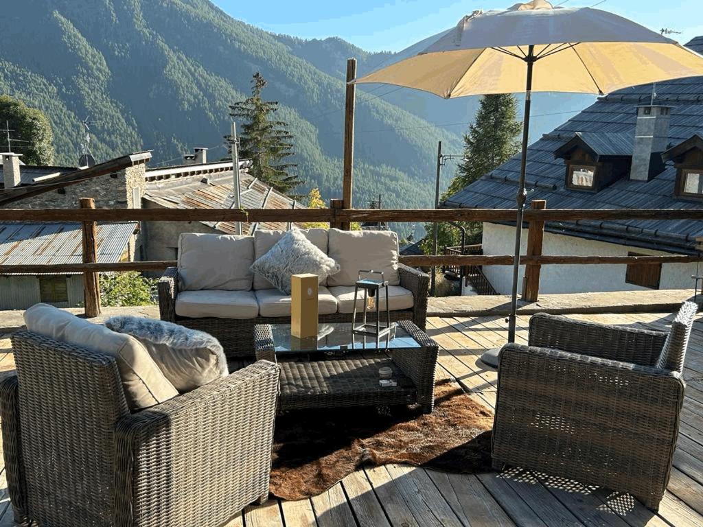 a patio with chairs and a table and an umbrella at chalet Sestriere in Champlas du Col