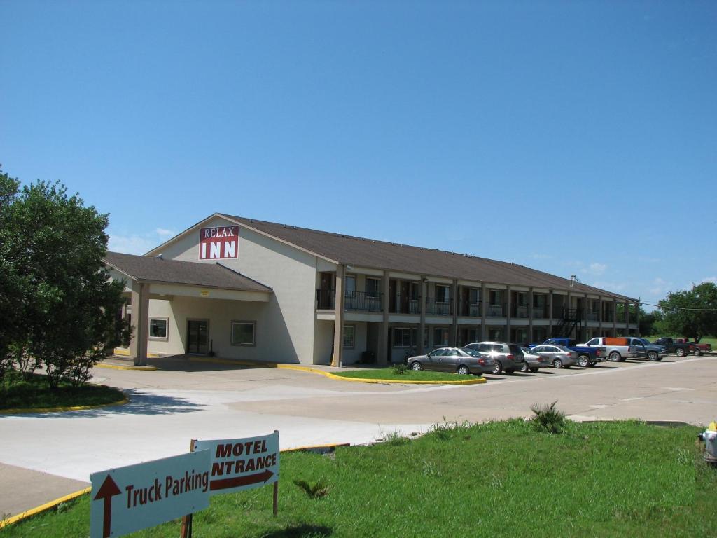 a hotel building with cars parked in a parking lot at Relax Inn Marlin in Marlin