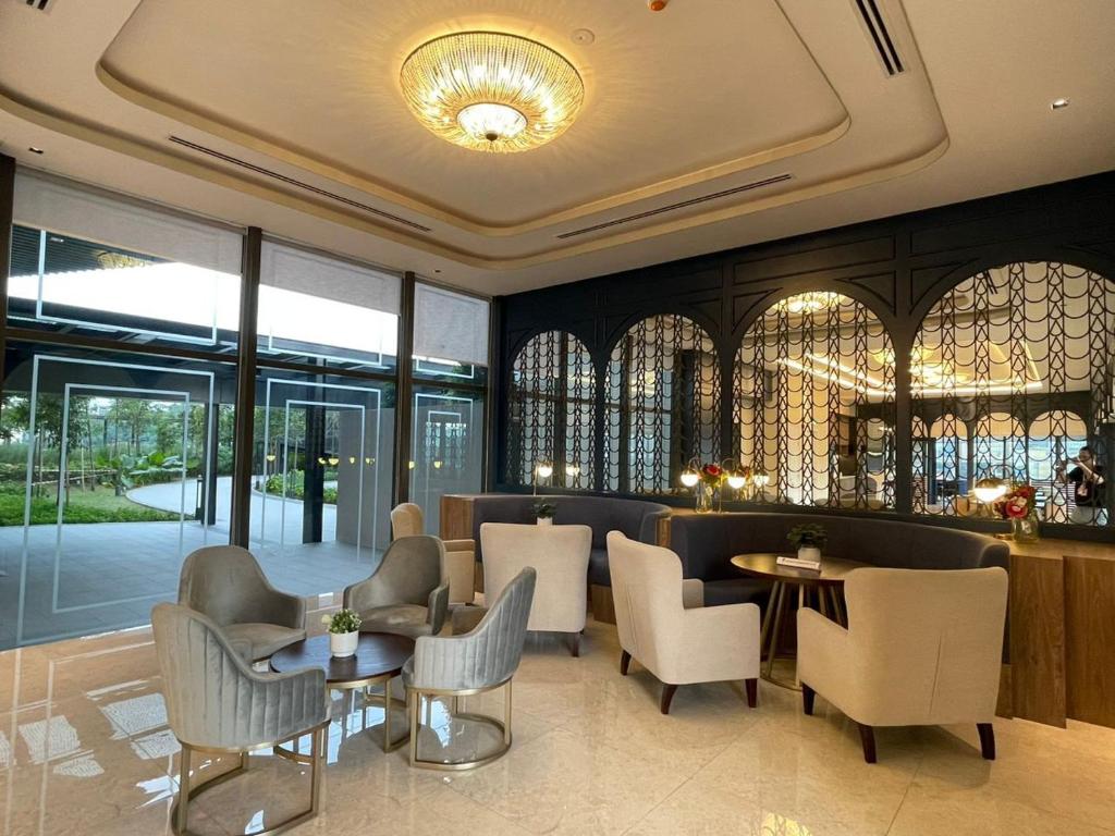um restaurante com cadeiras, mesas e janelas em Mid Valley Luxury 6pax Resort谷中城奢华风格套房 em Kuala Lumpur
