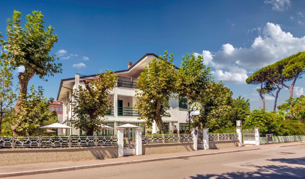 una casa blanca al lado de una carretera en Hotel Eura, en Marina di Massa