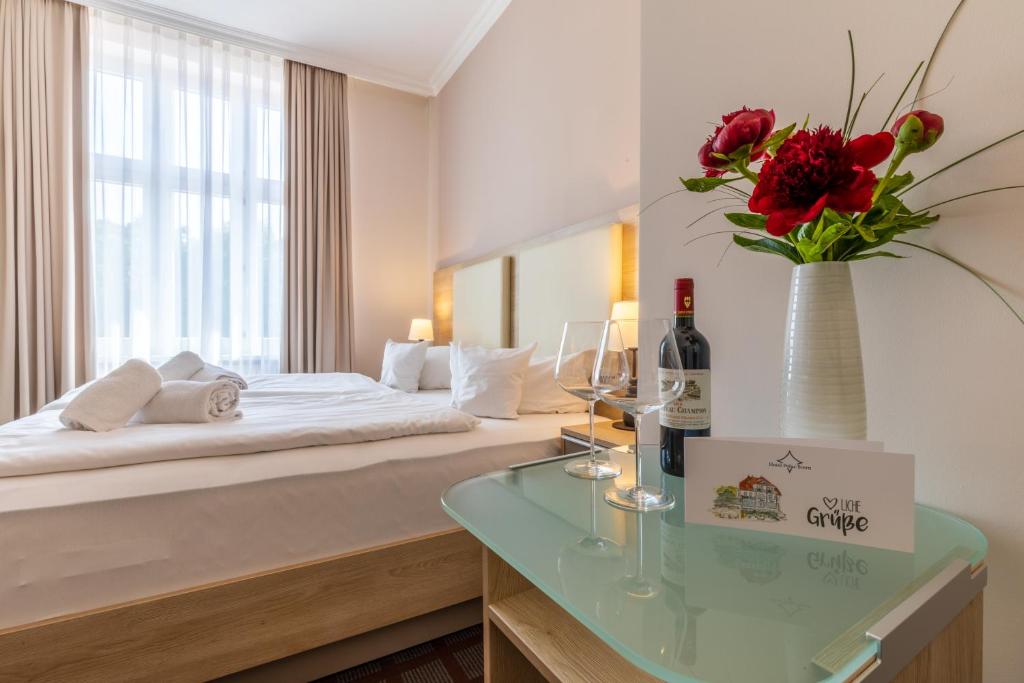 a hotel room with a bed and a vase of flowers at Hotel Polar-Stern in Kühlungsborn