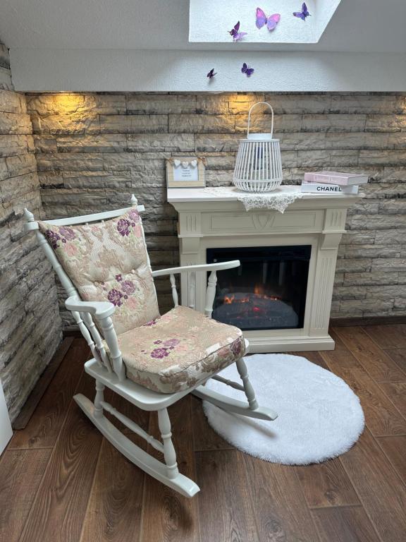 a rocking chair next to a desk with a fireplace at Apartman Senka in Budva
