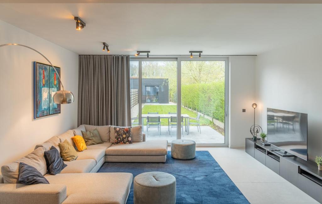 ein Wohnzimmer mit einem Sofa und einem Tisch in der Unterkunft Modern & Spacious House in Kortrijk