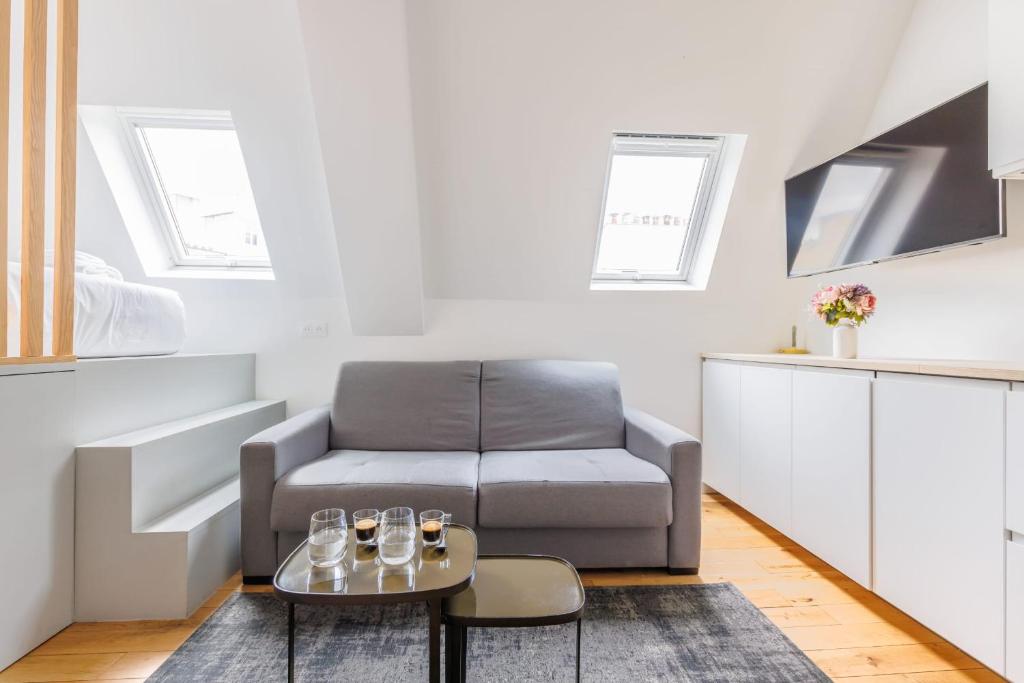 a living room with a couch and a table at Cosy Studio Etoile Friedland - MOBILITY LEASE in Paris