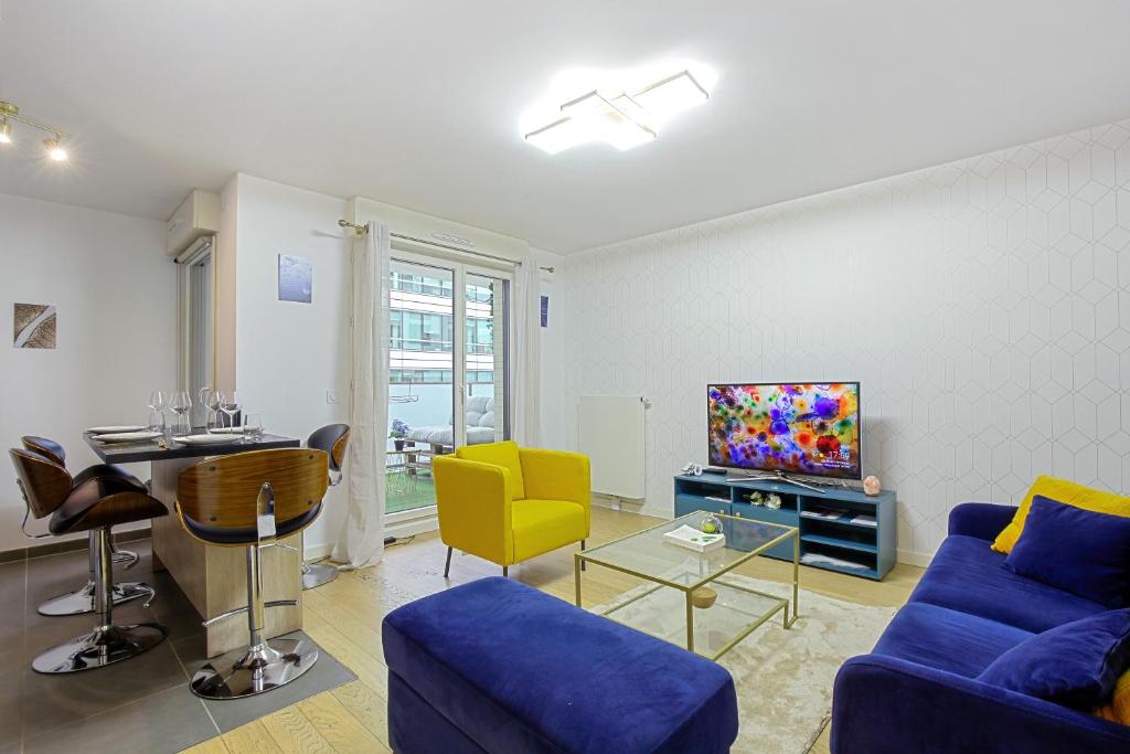 a living room with a blue couch and a tv at Chic apart with parking near Paris in Rueil-Malmaison