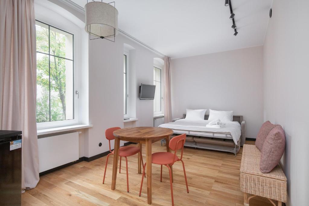 a room with a table and chairs and a bed at Stary Browar Cosy Studio in Poznań