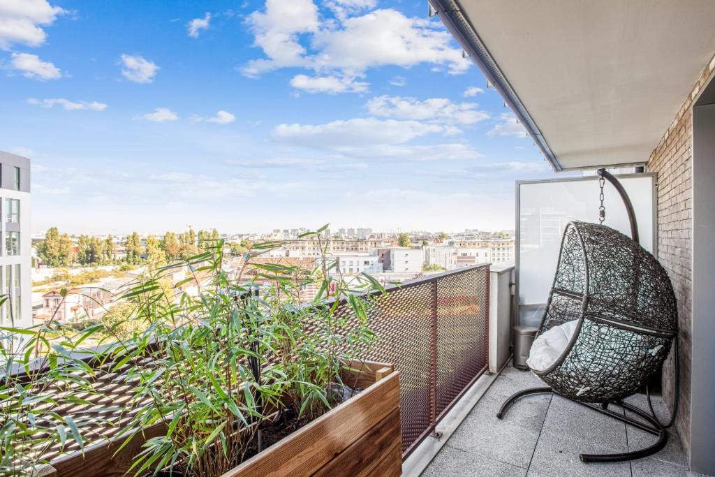 a balcony with a chair and a view of a city at Comfortable flat w views of Paris in Saint-Denis - Welkeys in Saint-Denis