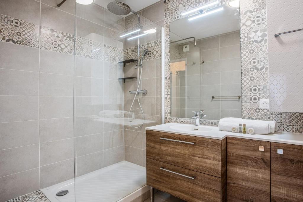 a bathroom with a shower and a sink and a mirror at Comfortable flat w views of Paris in Saint-Denis - Welkeys in Saint-Denis