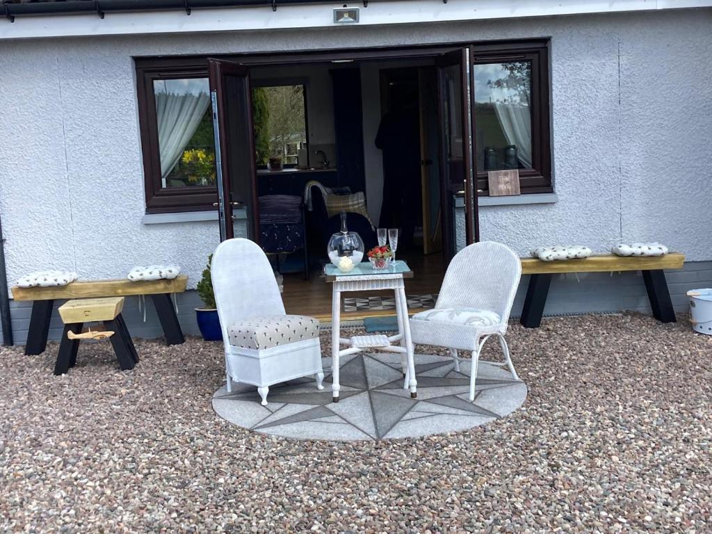two chairs and a table in front of a building at The Hive at Seonaidbheag in Perth