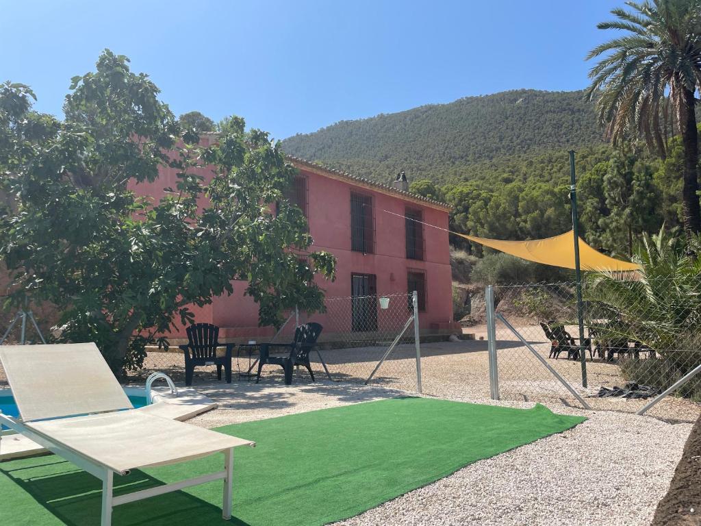 a yard with a ping pong court and a house at Casa Ramoncico. Finca el Campillo in Blanca