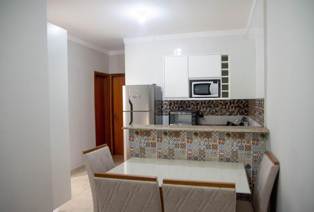 a kitchen with a table and chairs in a room at Geovane Acomodação in Boituva